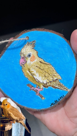 Portrait painting on wood slice of a cockatiel