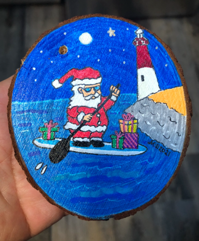 Paddleboard Santa painted on wood slice by Barnegat Lighthouse